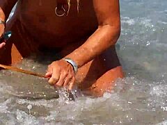 Zrela ženska z raztegnjenimi piercingi bradavičk in več piercingov v piercingih v piersingih na plaži